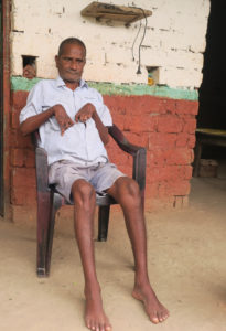 Freed Haliya Madan Damai sitting in front of this house